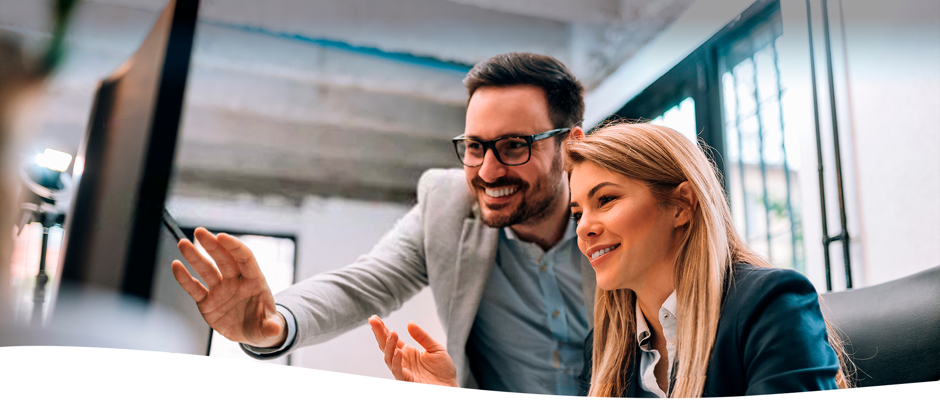 Dos personas sonriendo viendo una computadora